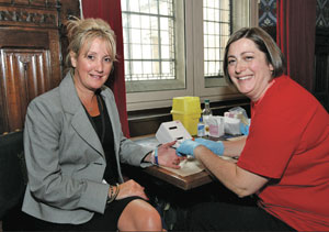 Caroline Dineage MP (left) having her cholesterol tested at the event